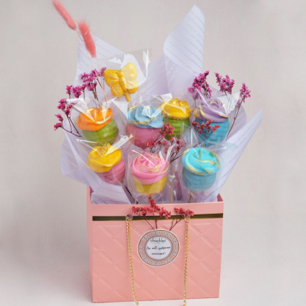 Луксозна подаръчна чантичка за 8 март от Chochko, аранжирана със 7 ванилови попкейка със захарни рози и шоколадова близалка пеперуда, с възможност за персонализиран стикер.
