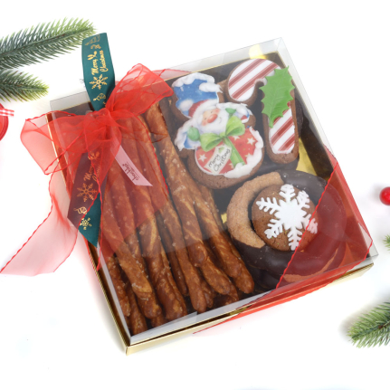 Луксозна Коледна кутия пълна с ръчно правени солени бретцели, сладки канелени гевречета и декорирани коледни меденки с натурален мед и ароматна канела.